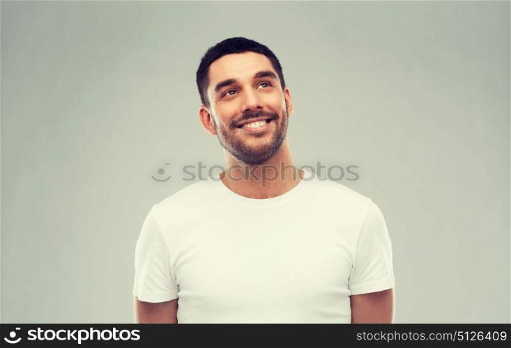advertisement, idea, inspiration and people concept - happy smiling young man looking up over gray. smiling man looking up over gray background