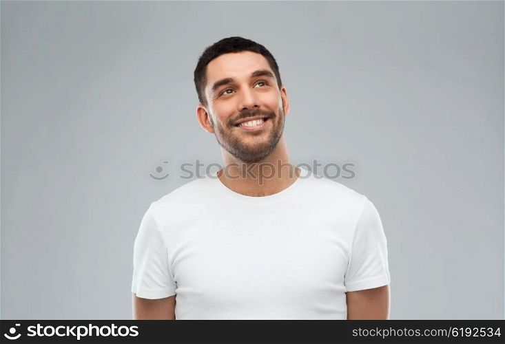 advertisement, idea, inspiration and people concept - happy smiling young man looking up over gray