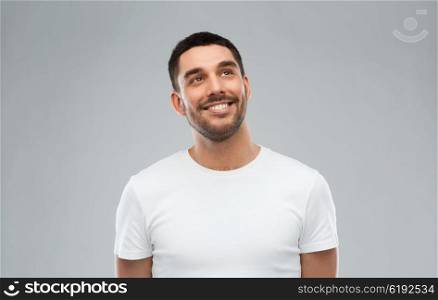 advertisement, idea, inspiration and people concept - happy smiling young man looking up over gray