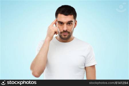 advertisement, idea, inspiration and people concept - man pointing finger to his temple over blue background