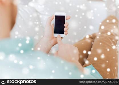 advertisement, people, home and technology concept - close up of man with smartphone sitting on couch at home