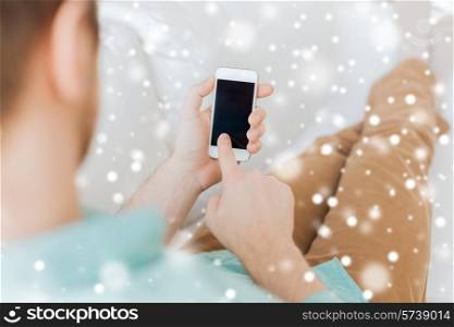 advertisement, people, home and technology concept - close up of man with smartphone sitting on couch at home