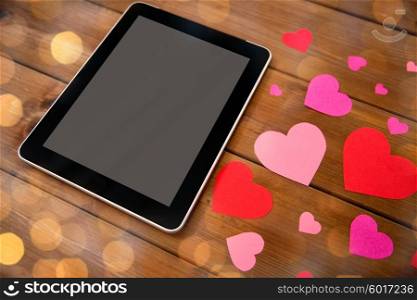 advertisement, romance, valentines day and holidays concept - close up of tablet pc computer and hearts on wood over golden lights