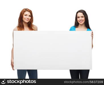 advertisement, sale and people concept - smiling young girls with blank white board