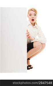 Advertisement. Surprised woman hiding behind blank copy space banner isolated on white. Businesswoman recommending your product