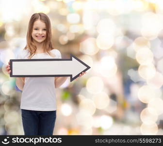 advertising and child concept - smiling little girl with blank arrow pointing right