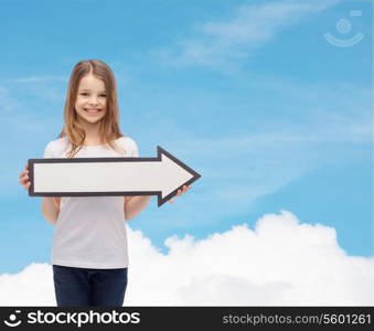 advertising and child concept - smiling little girl with blank arrow pointing right