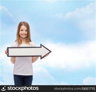 advertising and child concept - smiling little girl with blank arrow pointing right