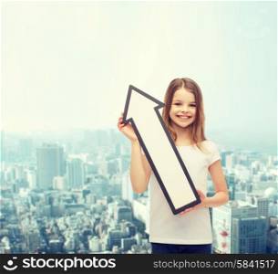 advertising and child concept - smiling little girl with blank arrow pointing up