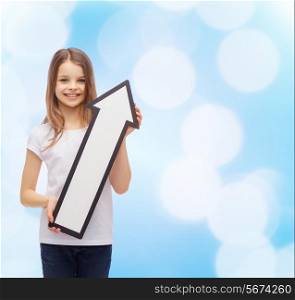 advertising and childhood concept - smiling little girl with blank arrow pointing up
