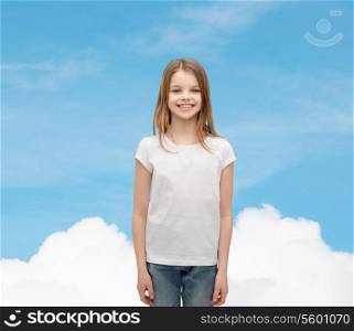advertising and t-shirt design concept - smiling little girl in white blank t-shirt over white background