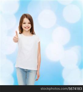advertising, childhood and people - smiling little girl in white blank t-shirt showing thumbs up gesture over blue background