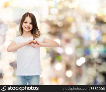 advertising, childhood, charity, holidays and people - smiling girl in white t-shirt making heart-shape gesture over sparkling background