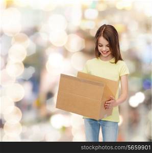 advertising, childhood, delivery, mail and people - smiling girl holding open cardboard box and looking into it over holidays background
