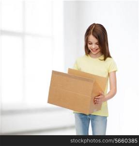 advertising, childhood, delivery, mail and people - smiling girl holding open cardboard box and looking into it over white room background