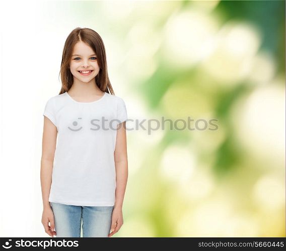 advertising, childhood, ecology and people - smiling little girl in white blank t-shirt over green background