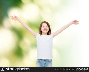 advertising, childhood, gesture, ecology and people - smiling little girl in white blank t-shirt with stretched out arms over green background