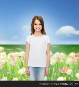 advertising, childhood, nature and people concept - smiling little girl in white blank t-shirt over flower field background