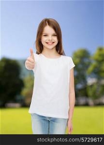 advertising, childhood, nature and people - smiling little girl in white blank t-shirt showing thumbs up gesture over green park background