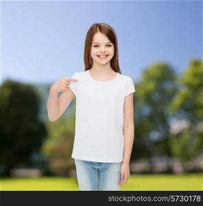advertising, childhood, nature, gesture and people - smiling girl in white t-shirt pointing finger on herself over green park background
