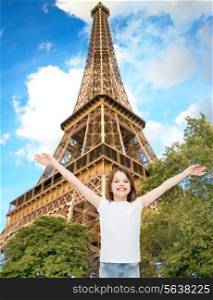 advertising, childhood, tourism, gesture and people concept - smiling girl in white t-shirt with raised arms over eiffel tower background