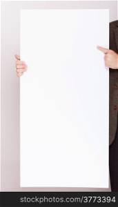 Advertising concept. Businessman holding blank sign empty billboard pointing space for text. Male hands with white banner.