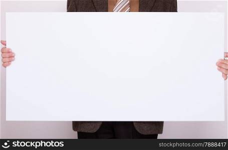 Advertising concept. Businessman holding blank sign empty billboard pointing space for text. Male hands with white banner.