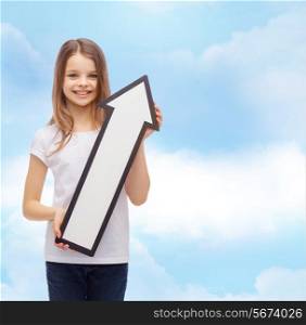 advertising, direction, air, aviation, and childhood concept - smiling little girl with white blank arrow pointing up over cloudy sky background