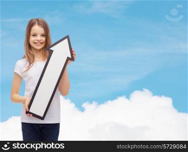 advertising, direction, air, aviation, and childhood concept - smiling little girl with white blank arrow pointing up over blue sky background