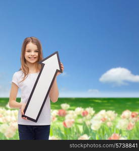 advertising, direction, nature, gardening and childhood concept - smiling girl with white arrow pointing up over flower field background