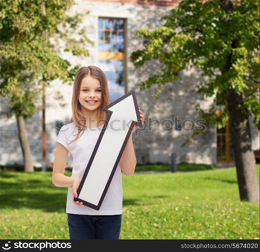 advertising, direction, summer vacation and childhood concept - smiling little girl with white blank arrow pointing up over campus background