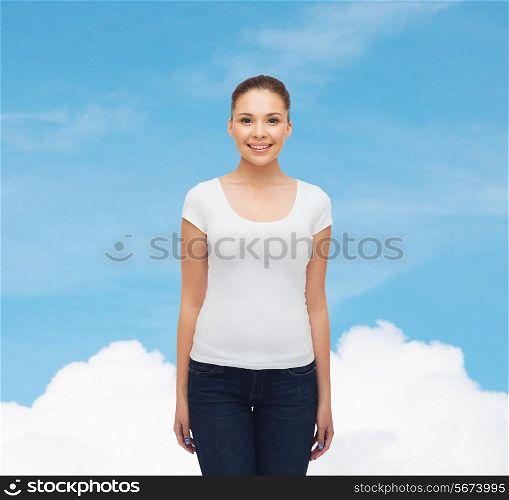 advertising, dream and people concept - smiling young woman in blank white t-shirt over blue sky background