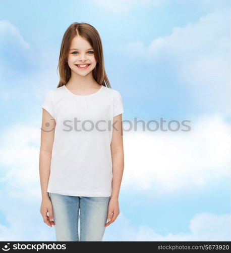 advertising, dream, childhood and people - smiling little girl in white blank t-shirt over cloudy sky background