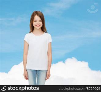 advertising, dream, childhood and people - smiling little girl in white blank t-shirt over blue sky background