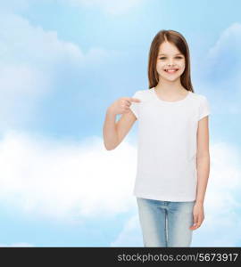 advertising, dream, childhood, gesture and people - smiling little girl in white t-shirt pointing finger on herself over cloudy sky background