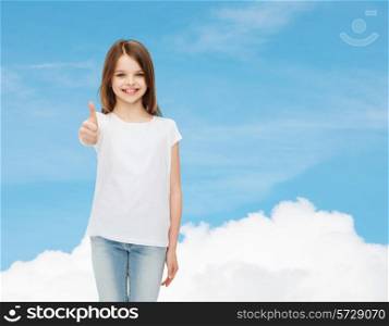 advertising, dream, childhood, gesture and people - smiling little girl in white blank t-shirt showing thumbs up over blue sky background