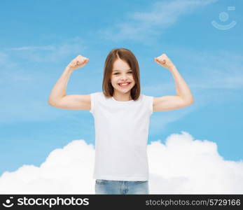 advertising, dream, childhood, gesture and people - smiling little girl in white blank t-shirt with raised arms over blue sky background