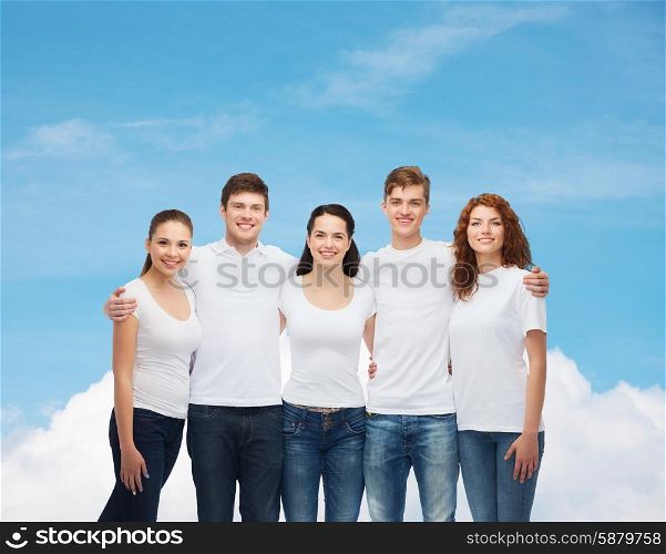 advertising, dream, future and people concept - group of smiling teenagers in white blank t-shirts over blue sky with white cloud background