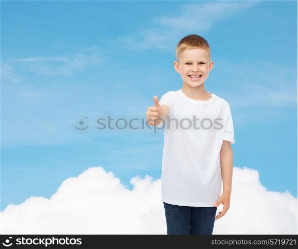 advertising, dream, gesture, people and childhood concept - smiling little boy in white blank t-shirt showing thumbs up over sky background