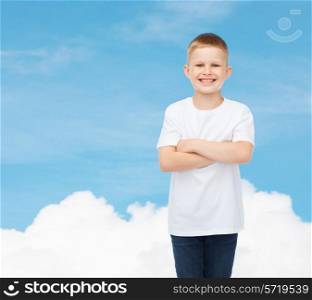 advertising, dream, people and childhood concept - smiling little boy in white blank t-shirt over sky background