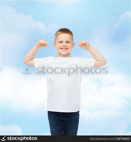 advertising, dream, people and childhood concept - smiling little boy in white blank t-shirt with raised hands over cloudy sky background