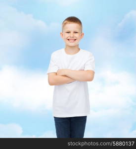 advertising, dream, people and childhood concept - smiling little boy in white blank t-shirt over cloudy sky background