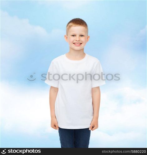 advertising, dream, people and childhood concept - smiling little boy in white blank t-shirt over cloudy sky background