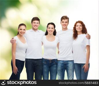 advertising, ecology, nature, friendship and people concept - group of smiling teenagers in white blank t-shirts over green background
