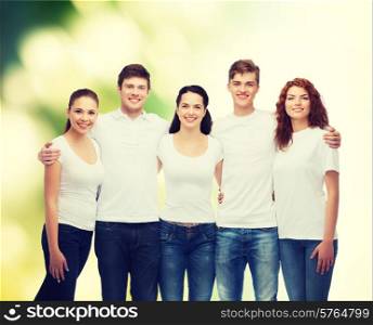 advertising, ecology, nature, friendship and people concept - group of smiling teenagers in white blank t-shirts over green background