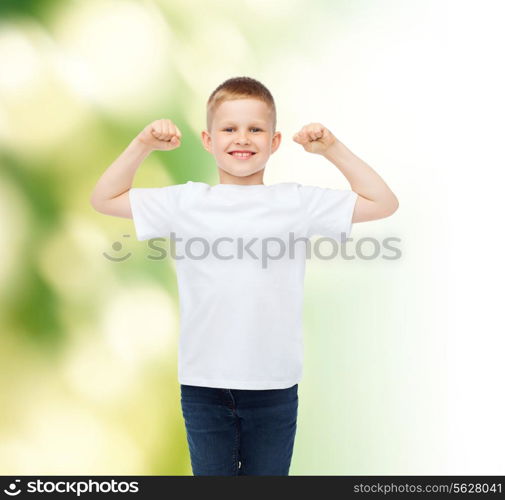 advertising, ecology, people and childhood concept - smiling little boy in white blank t-shirt over green background