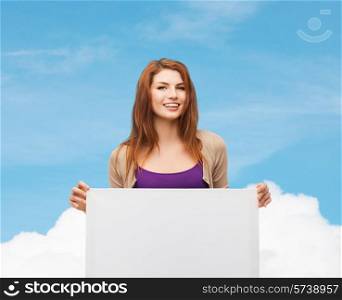 advertising, education and people concept - smiling teenage girl with blank white board over blue sky and cloud background