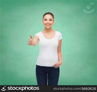 advertising, education, school, gesture and people concept - smiling young woman in blank white t-shirt showing thumbs up over green board background