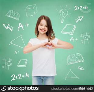 advertising, gesture, charity, education and people - smiling little girl in white blank t-shirt showing heart-shape gesture over green board with doodles background