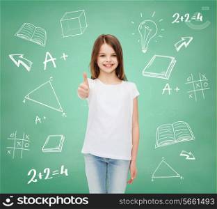 advertising, gesture, education, childhood and people - smiling little girl in white t-shirt showing thumbs up over green board with doodles background